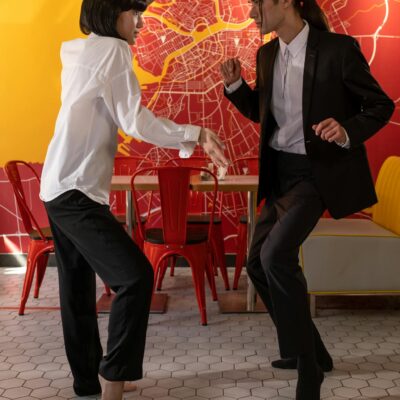 A couple elegantly poses in a café with a vibrant wall map.