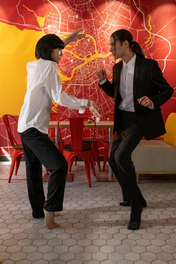 A couple elegantly poses in a café with a vibrant wall map.