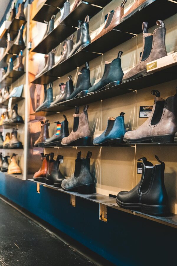 Elegant leather boots on display shelves in a fashion retail store.